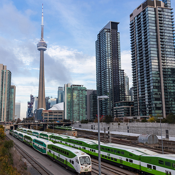 TORONTO, CANADA - October 21, 2019: GO Transit Train rail depot seen with CN Tower and Rogers Centre in behind on sunny day.
